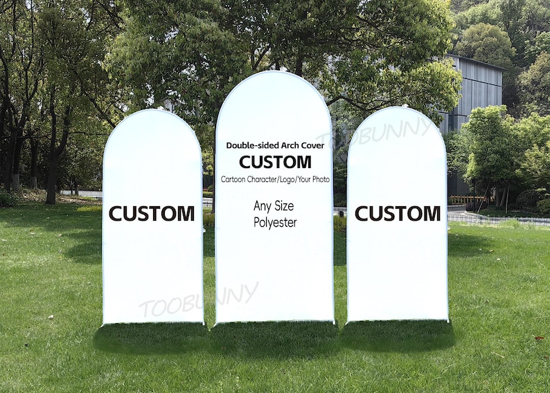May include: Three white, arched fabric covers with the word "CUSTOM" in bold black letters. The center cover has text that reads "Double-sided Arch Cover", "CUSTOM", "Cartoon Character/Logo/Your Photo", "Any Size", and "Polyester". The covers are on a grassy lawn.