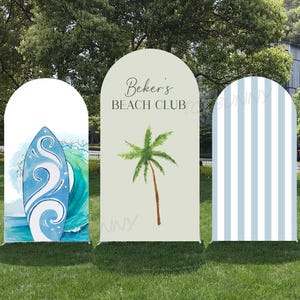 Könnte beinhalten: Drei bogenförmige Außenschilder mit Strandmotiven. Eines zeigt ein blaues Surfbrett mit Wellendetails, ein anderes eine Palme und den Text "Beker's BEACH CLUB", und das dritte hat blau-weiße Streifen.