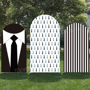 Op de afbeelding: Drie decoratieve panelen met pak- en stropdasontwerpen. Eén paneel heeft een zwart pak met een witte kraag en zwarte stropdas. Een ander heeft een witte achtergrond met blauwe en zwarte stropdaspatronen. Het derde paneel heeft zwart-witte verticale strepen.