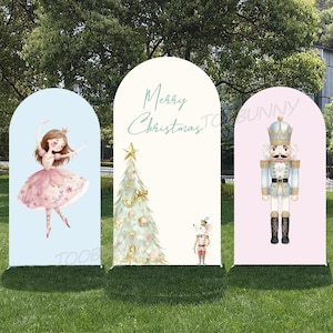 May include: Three arched Christmas-themed yard signs. One features a ballerina in a pink dress, another has a Christmas tree and the text "Merry Christmas", and the third displays a nutcracker.