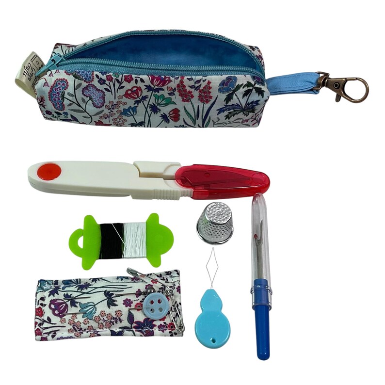 May include: A floral print zippered pouch with a metal clip, containing a white and red seam ripper, a green thread spool, a silver thimble, a blue needle threader, a blue seam ripper with a clear cap, and a floral fabric needle case with pins.