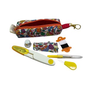 May include: A small zippered pouch with a colorful mushroom print, a metal thimble, a fabric needle case, a spool of black and white thread, a yellow seam ripper, a yellow needle threader, and a yellow marking pen with a clear cap.