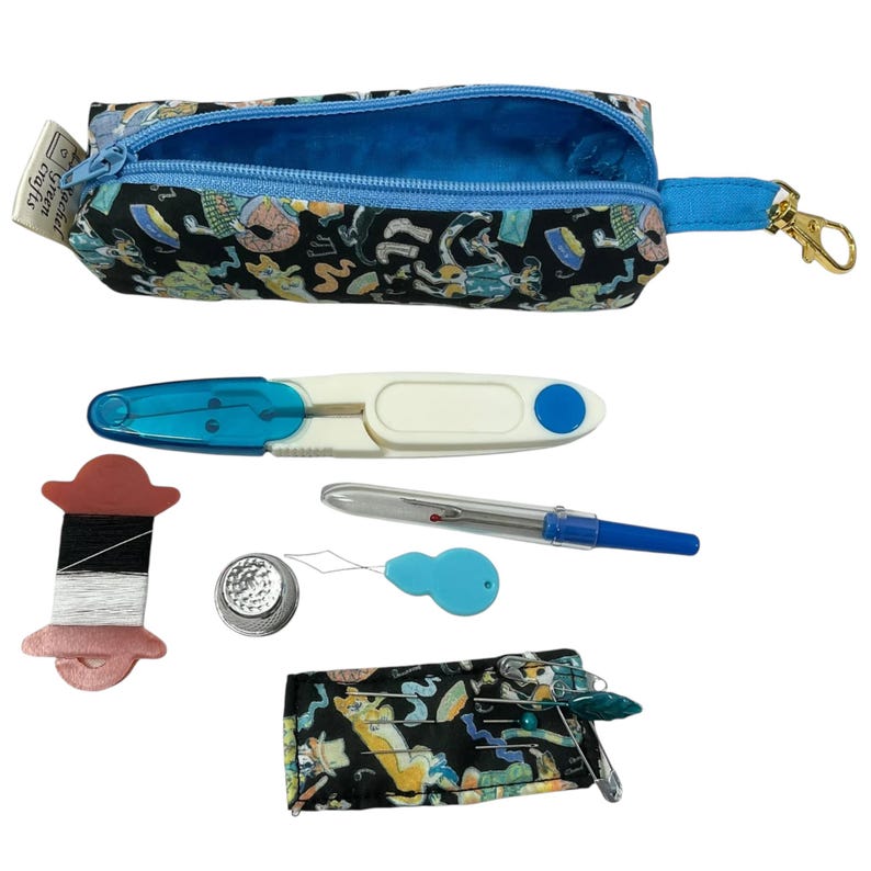May include: A black fabric pouch with a dog print and blue zipper, containing a white and blue threader, a seam ripper, a spool with black and white thread, a metal thimble, a blue needle threader, and a small needle case with pins.