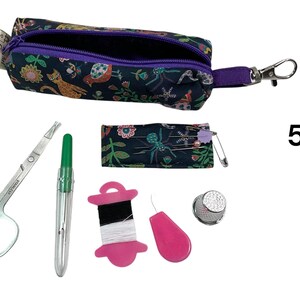 May include: A dark fabric sewing kit featuring a zippered pouch with a floral and animal print, a small needle case, stainless steel scissors, a green seam ripper, a pink thread spool, a pink needle threader, and a metal thimble, labeled with the number 5.