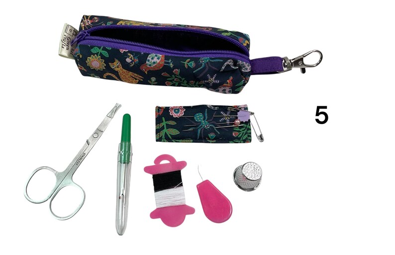 May include: A dark fabric sewing kit featuring a zippered pouch with a floral and animal print, a small needle case, stainless steel scissors, a green seam ripper, a pink thread spool, a pink needle threader, and a metal thimble, labeled with the number 5.