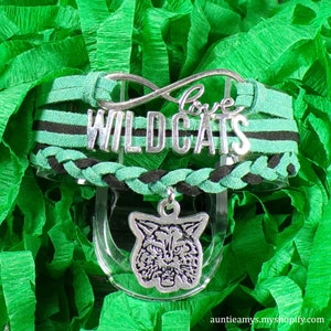 May include: Green and black braided bracelet with a silver charm that says "Love Wildcats" and a silver wildcat charm.