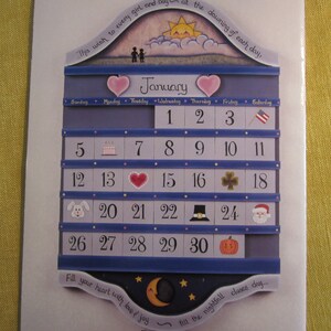 May include: A blue and white wooden calendar with a heart-shaped design. The calendar is for January and features a different icon for each day. The text "This wish to every girl and boy at the dawning of each day" is at the top of the calendar.