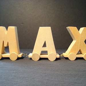 May include: Wooden toy train with the name MAX spelled out in block letters. Each letter is on a separate car with wheels.