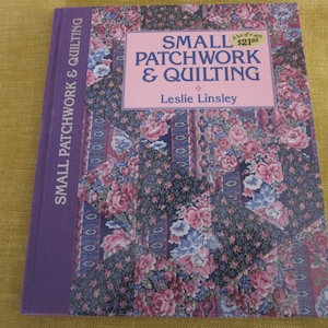 May include: A purple book titled "Small Patchwork & Quilting" by Leslie Linsley. The cover features a floral pattern with pink and blue flowers on a dark background.