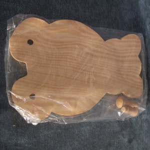May include: Unfinished wooden bear cutout with two wooden dowels. The bear is in a clear plastic bag.