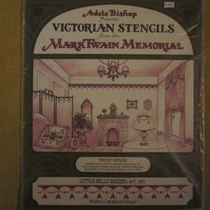 May include: A vintage-style package for Victorian stencils from the Mark Twain Memorial. The package features a drawing of a room with a fireplace, a window, and a screen. The text on the package reads "Victorian Stencils from the Mark Twain Memorial." The package also includes a sample of the "Little Bells Border" stencil.