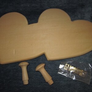 May include: Two unfinished wooden hearts joined together, with two wooden knobs and a package of gold-colored hanging hardware.