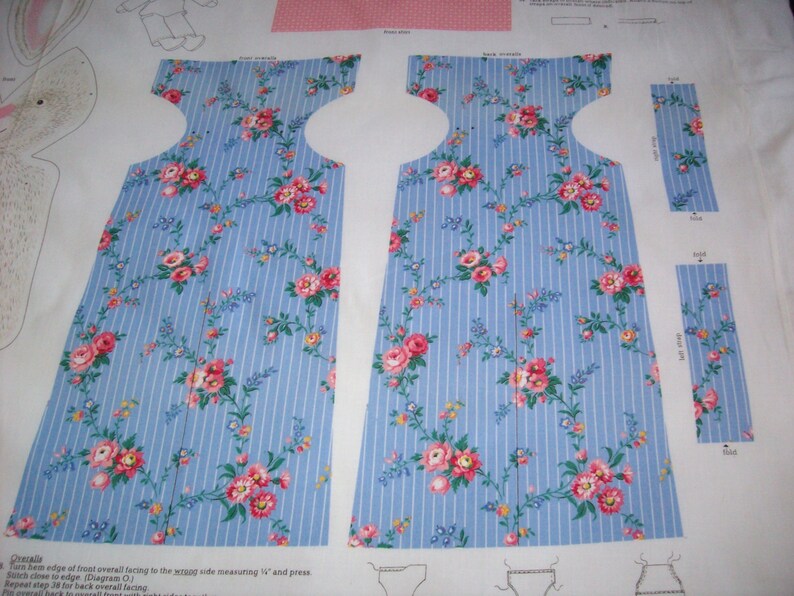 May include: A sewing pattern for a dress with a blue and white striped fabric with pink floral accents. The pattern includes instructions for sewing the dress and a diagram of the dress.
