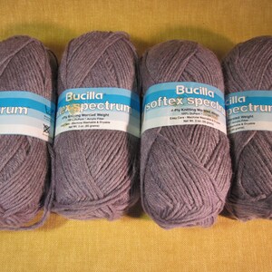 May include: Four skeins of gray Bucilla Spectrum yarn, a 4-ply knitting worsted weight yarn. The label reads "Bucilla Spectrum 4-Ply Knitting Worsted Weight 100% Acrylic Fiber Easy Care - Machine Washable & Dryable Net Wt. 3 oz. (85 grams)"