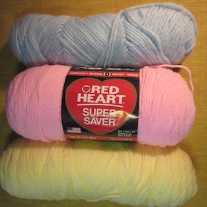 3 skeins yarn, pink, yellow, light baby blue, red heart, dazzleaire, 15 oz. total wt., worsted wt., knitting, crochet