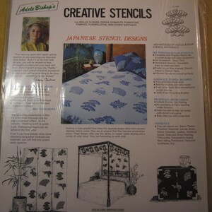 May include: A close-up of a package for Japanese stencil designs. The package features a black and white image of a four-panel screen with a floral design. The text on the package reads "Adele Bishop's Creative Stencils" and "Japanese Stencil Designs".