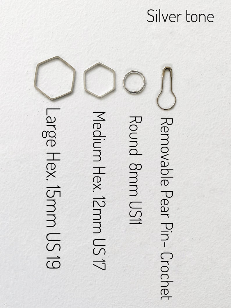 May include: Four silver-toned crochet hooks: a large hexagon hook (15mm, US 19), a medium hexagon hook (12mm, US 17), a round hook (8mm, US 11), and a removable pear-shaped crochet pin.