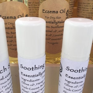 Puede incluir: Tres tubos blancos de aceite calmante para el eczema con etiquetas marrones. Las etiquetas dicen "Soothing Essentially Natural" y enumeran los ingredientes, que incluyen aceite de oliva, aceite de cáñamo, manteca de cacao, aloe vera, hierba de San Juan, caléndula y árbol de té.