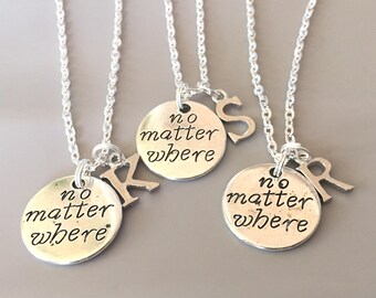 May include: Three silver necklaces with charms. Each charm has the words "no matter where" and a letter. The letters are K, S, and R.