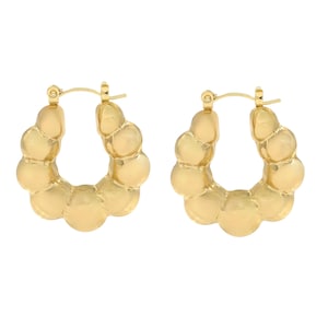 May include: A pair of gold-colored hoop earrings. Each earring features a series of rounded, textured segments, creating a bubbly appearance. The earrings have a classic hoop design with a secure clasp.