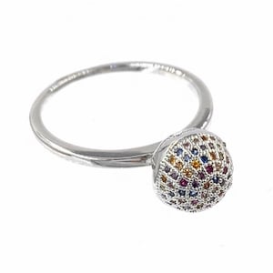 May include: A silver ring with a round, multi-colored gemstone. The gemstone is set with small, colorful stones in a circular pattern.