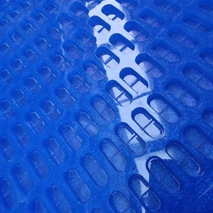 May include: A blue plastic tray with a grid of oval-shaped indentations. The tray is designed for holding and organizing small items.