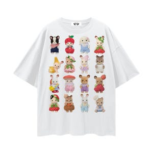 May include: White t-shirt featuring a grid of colorful, cartoon animal characters. The characters are dressed in various outfits and accessories, including hats, dresses, and overalls. The shirt has a crew neck and short sleeves.