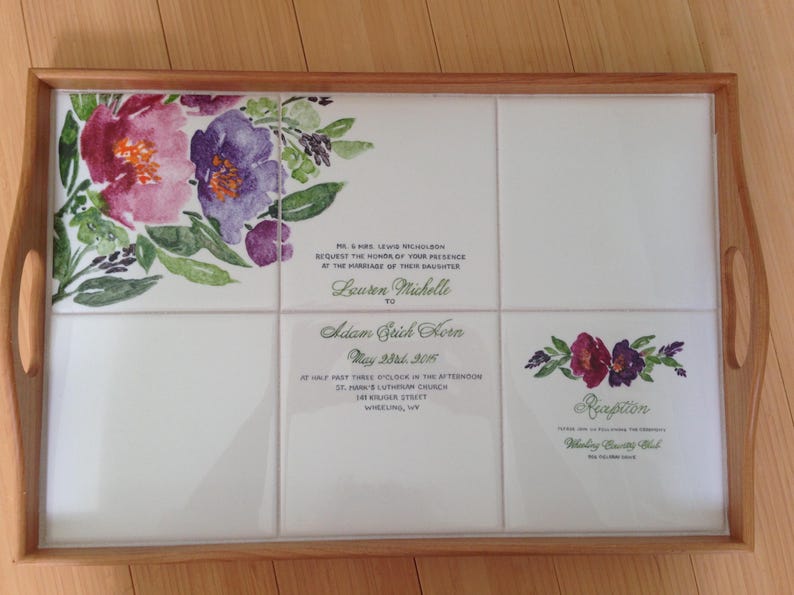 Puede incluir: Bandeja rectangular con marco y asas de madera. La superficie de la bandeja est&aacute; compuesta por baldosas blancas, adornadas con dise&ntilde;os florales en acuarela en rosa, morado y verde. Texto de invitaci&oacute;n de boda impreso en las baldosas.