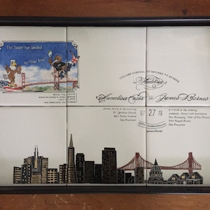 May include: A decorative serving tray with a black frame and handles. The tray features a design of San Francisco landmarks and a wedding invitation with the text "The Eagle has landed".