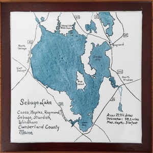 Puede incluir: Un mapa dibujado a mano del lago Sebago en Maine, que muestra el contorno del lago, las ciudades circundantes y las carreteras cercanas. El lago está coloreado de azul, y el texto "Sebago Lake" está escrito en cursiva negra. El texto "Casco, Naples, Raymond, Sebago, Standish, Windham, Cumberland County, Maine" está escrito debajo del lago. El texto "Areas 29,992 Acres, Perimeter: 98.2 miles, Max. depth: 316 feet" está escrito en la esquina inferior derecha.
