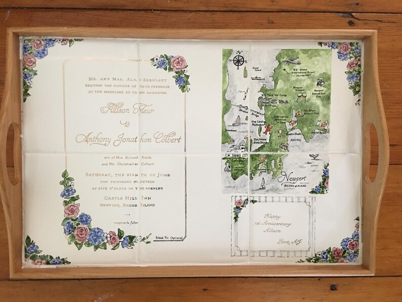 Puede incluir: Bandeja de madera con dise&ntilde;o floral y mapa. La bandeja presenta una invitaci&oacute;n de boda y un mapa de Newport, Rhode Island. La invitaci&oacute;n incluye los nombres Allison y Anthony, y la fecha de la boda.