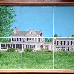 Puede incluir: Una bandeja rectangular con una escena de paisaje pintada. La obra de arte representa una gran casa gris con un porche, sobre un cielo azul y césped verde. La bandeja tiene un marco y asas de madera clara.