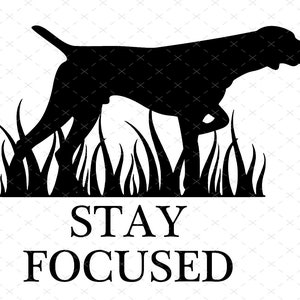 May include: Black silhouette of a dog standing in tall grass with the text "STAY FOCUSED" below.