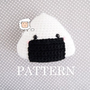 May include: A white crocheted amigurumi onigiri with black seaweed and pink cheeks. The onigiri has black eyes and the text "PATTERN" is below it.