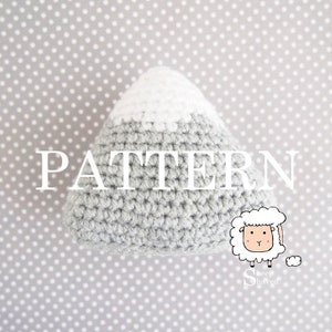 Könnte beinhalten: Häkelanleitung für einen grauen Berg mit einer weißen Schneehaube. Das Muster ist mit "PATTERN" betitelt und zeigt eine niedliche Cartoon-Schaf-Illustration.