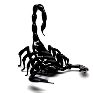 May include: A black glass scorpion sculpture with a curled tail and detailed legs.