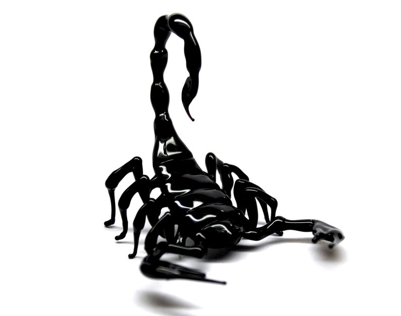 May include: A black glass scorpion sculpture with a curled tail and detailed legs.