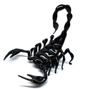 May include: A black glass scorpion sculpture with a curled tail and detailed legs.