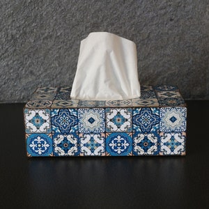 May include: Tissue box cover with a blue and white patterned design. The design features geometric shapes and floral motifs.