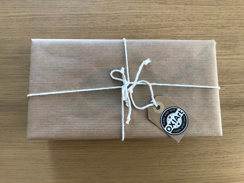 May include: A brown paper package tied with white string and a brown tag that says "OXIAFT made with love made with love".