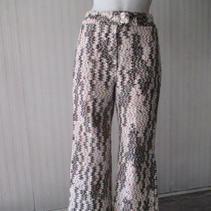 May include: Wide-leg trousers with a black, white and brown abstract pattern. The trousers have a button fastening and a high waist.