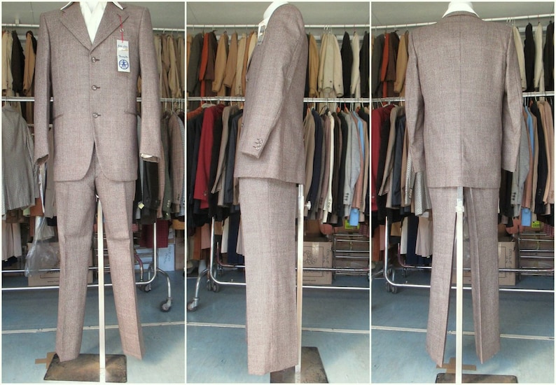 May include: A brown patterned suit jacket and pants on a mannequin. The suit is displayed in a clothing store.