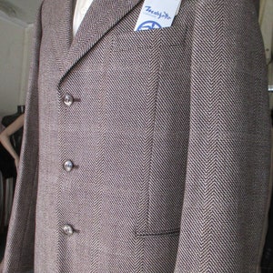 May include: A brown and white herringbone blazer with three buttons and a pocket on the left side. The blazer has a label that says "T. Marzotto" and "Fuso Doro".