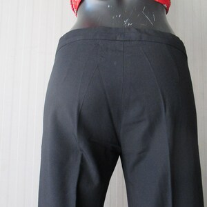 May include: Black, tailored pants with a straight leg. The pants are made of a smooth fabric and have a classic design. The waistline is visible, and the pants appear to be well-fitted. A timeless wardrobe staple.