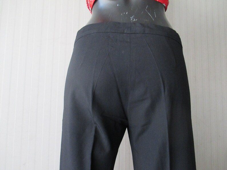 May include: Black, tailored pants with a straight leg. The pants are made of a smooth fabric and have a classic design. The waistline is visible, and the pants appear to be well-fitted. A timeless wardrobe staple.