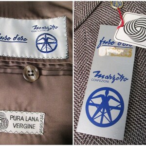 May include: Two brown and white fabric labels with the text "Marzotto Confezioni" and "Fuso d'Oro" in blue. The labels also feature a blue circular logo with a stylized figure and a compass rose. A third label reads "Pura Lana Vergine" in black text with a black and white yarn graphic.