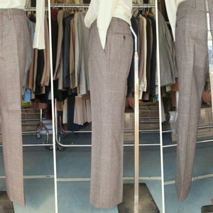 May include: A pair of brown plaid pants on a mannequin. The pants have a straight leg and a classic fit.