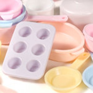 May include: A set of pastel-coloured plastic kitchen play food toys. The set includes a muffin tin, a frying pan, a saucepan, and several bowls.