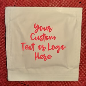 Może przedstawiać: Biały jednorazowy ręcznik do rąk z nadrukowanym tekstem "Your Custom Text or Logo Here" w kolorze różowym.