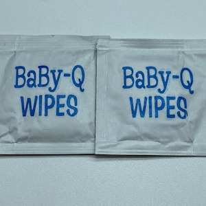 May include: Two individual packets of Baby-Q wipes, each with the brand name printed in blue on a white background.